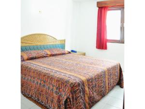 1 dormitorio con 1 cama con manta y ventana en Highfive Guest House, en Pattaya central