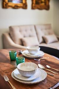 a wooden table with plates and bowls on top of it at Casa Palacio Reina de Tardajos in Vinuesa