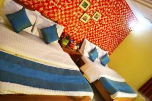 a bedroom with a bed with blue and white pillows at Hotel HRS - New Delhi Railway Station in New Delhi