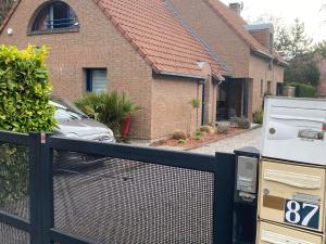 a fence in front of a house with a parking meter at Chambre confortable avec une entrée indépendante - Parking & accès Lille facile in Marcq-en-Baroeul