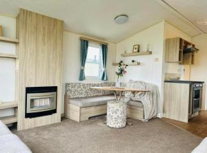 ein Wohnzimmer mit einem Tisch und einem Sofa in der Unterkunft The salsa golden gate towyn in Kinmel Bay