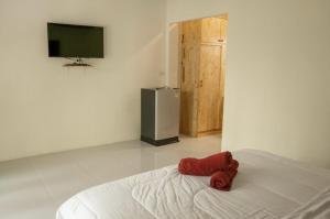 a red stuffed animal sitting on a bed in a room at Seaside Sanctuary Bungalows in Ko Lanta