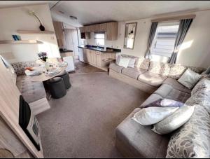 ein Wohnzimmer mit einem Sofa und einem Tisch in der Unterkunft The salsa golden gate towyn in Kinmel Bay
