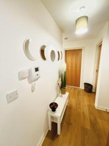 Zimmer mit weißen Wänden und einem Tisch auf einem Holzboden in der Unterkunft Starberry Court in London
