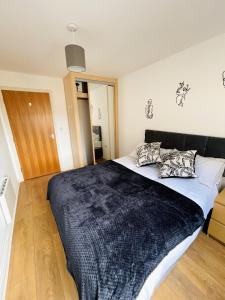 ein Schlafzimmer mit einem großen Bett mit einer schwarzen Decke in der Unterkunft Starberry Court in London