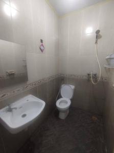 a bathroom with a white toilet and a sink at SPOT ON 93853 Budi Residence 2 in Bekasi