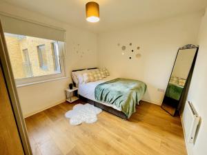 ein Schlafzimmer mit einem Bett und einem Spiegel auf dem Boden in der Unterkunft Starberry Court in London