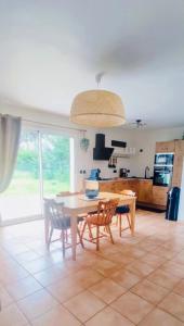 een keuken en eetkamer met een tafel en stoelen bij La maison du bonheur in Saint-Jean-de-la-Rivière