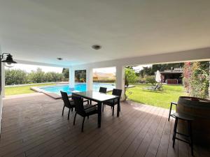 a patio with a table and chairs and a pool at Villa Los Gallos in Almuñécar