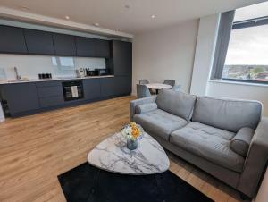 - un salon avec un canapé et une table dans l'établissement Lovely 1 Bed Apartment - Old Trafford, à Manchester