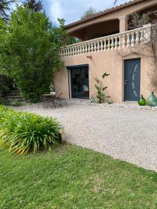 ein Haus mit einer Terrasse und einem Rasenhof in der Unterkunft La carolienne in Vallauris