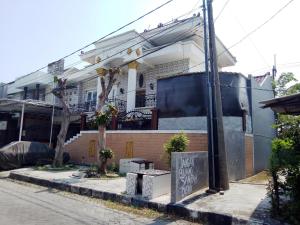 una casa con un cartel delante de ella en SPOT ON 93880 Guest House Bu Iin Syariah en Sidoarjo