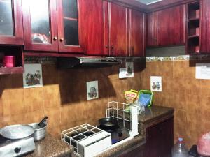 a kitchen with wooden cabinets and a stove top oven at SPOT ON 93880 Guest House Bu Iin Syariah in Sidoarjo