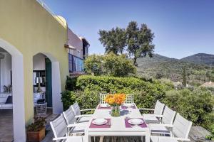 a table and chairs on a patio with mountains in the background at Les Bastides 3028 in Grimaud