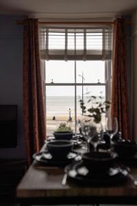a dining room table with a view of the ocean at Margate Bliss 3Bed House Steps Away from the Beach in Margate