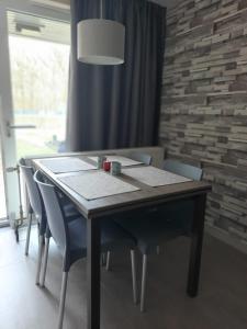 a dining room table with chairs and aendant light at Hengelhoef Berk 5 in Houthalen-Helchteren