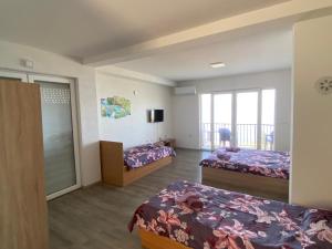 a bedroom with two beds and a balcony at RISTESKI GUEST HOUSE in Ohrid