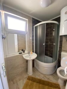 uma casa de banho com um lavatório, um chuveiro e um WC. em RISTESKI GUEST HOUSE em Ohrid