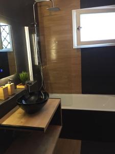 ein Badezimmer mit einer schwarzen Schüssel auf der Theke in der Unterkunft Le Vauban avec les cles de Luz in Saint-Jean-de-Luz