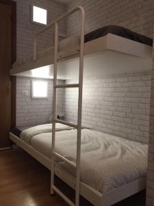 ein weißes Etagenbett in einem Zimmer mit Ziegelwand in der Unterkunft Le Vauban avec les cles de Luz in Saint-Jean-de-Luz