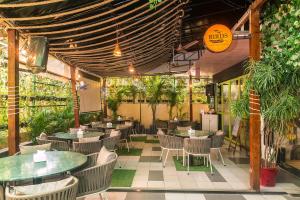 a restaurant with tables and chairs and plants at Hotel Orritel West in Mumbai