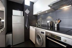eine Küche mit einer Waschmaschine und einem Geschirrspüler in der Unterkunft Le Vauban avec les cles de Luz in Saint-Jean-de-Luz