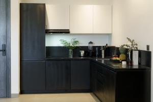 a black and white kitchen with white cabinets at Sunny Aparts 1 in Canggu
