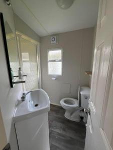 uma casa de banho com um lavatório branco e um WC. em Two bedroom Caravan with Sea Views, Warden Springs Eastchurch em Warden