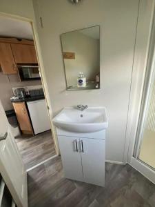 a bathroom with a sink and a mirror at Two bedroom Caravan with Sea Views, Warden Springs Eastchurch in Warden