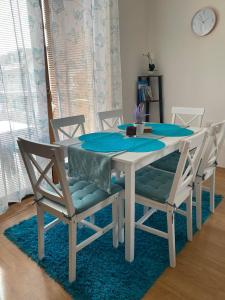 a white dining room table with chairs and a blue rug at Apartmán Diana in Oščadnica