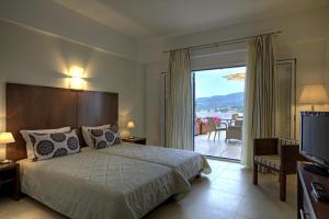 a hotel room with a bed and a sliding glass door at Kythea Resort in Agia Pelagia +33 photos