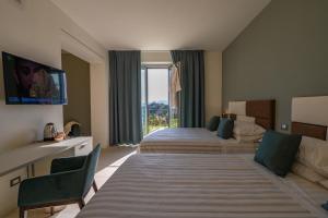 a hotel room with two beds and a large window at AGRITURISMO TERRA VOLONTERI in Montecatini Terme