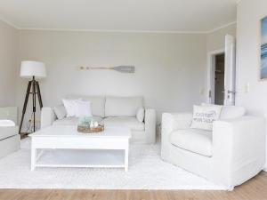 a white living room with a couch and a table at Techts Strandhaus in Timmendorfer Strand