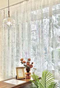 a vase of flowers on a table with a window at 永安101 Wing on x 附陽台 in Taitung City