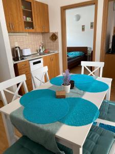 a kitchen with a table with blue cushions on it at Apartmán Diana in Oščadnica