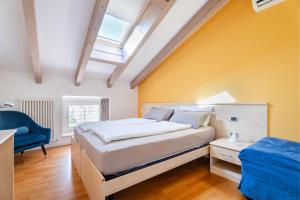 una camera con letto e sedia blu di Villa Aranci Downtown a Riva del Garda