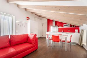 un soggiorno con divano rosso e una cucina di Villa Aranci Downtown a Riva del Garda