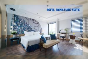 a hotel room with a bed and a dining room at Sofiana My Khe Hotel & Spa- Rooftop Pool Bar in Danang +37 photos