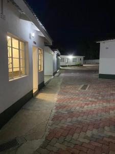 um pátio vazio à noite com um edifício em Cumberland Guest Lodge em Bulawayo