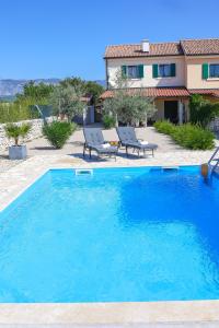 a large blue swimming pool in front of a house at Villa Niko Your vacation starts here in Rudine