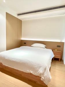 um quarto com uma grande cama branca em Pikkie Designer's Stylish Three Bed Room Apartmemt em Zhangjiajie