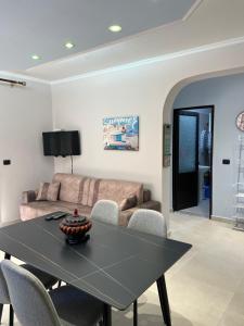 ein Wohnzimmer mit einem Tisch und einem Sofa in der Unterkunft SKetch Apartments 2 in Durrës