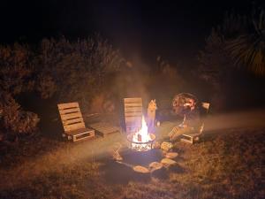 a person sitting next to a fire pit at night at Danseys Pass Lavender Farm in Tokarahi