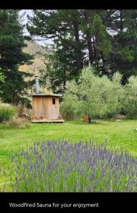 a wooden sauna in a field with purple flowers at Danseys Pass Lavender Farm in Tokarahi