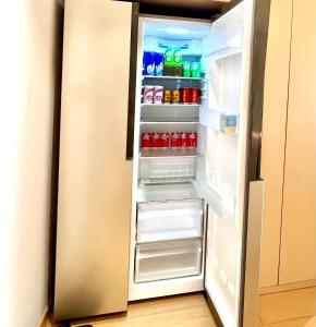 um frigorífico aberto cheio de bebidas e refrigerantes em Pikkie Designer's Stylish Three Bed Room Apartmemt em Zhangjiajie