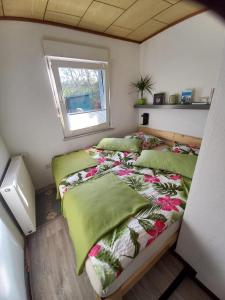 een kleine slaapkamer met 2 bedden en een raam bij Ferienhaus Hilde in Sangerhausen