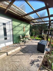 un patio con una pared verde y una pérgola de madera en Ferienhaus Hilde, en Sangerhausen