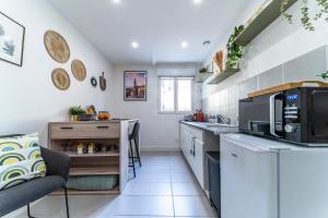 a kitchen with a sink and a microwave at LE COSY - Free Parking - Proche Gares Lille - Netflix - Wifi in Mons-en-Baroeul