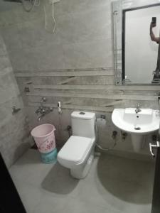 a bathroom with a toilet and a sink at Hotel Best Velly in Gandhinagar