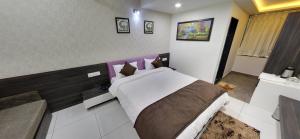a bedroom with a large bed with a purple headboard at Hotel Best Velly in Gandhinagar
